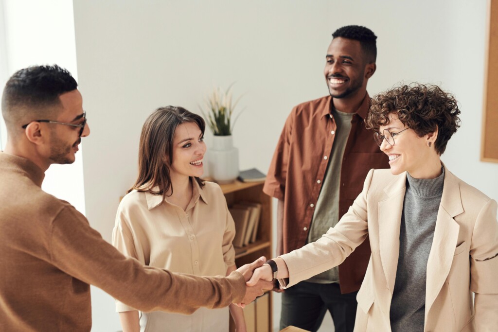 A group of employees reaching consensus on ownership. Two people shaking hands, showing trust.